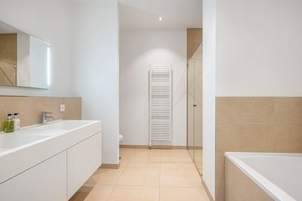 Masterbadezimmer mit Badewanne und Dusche