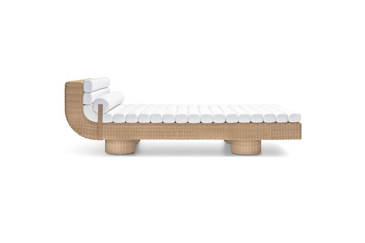 Cut-out sun lounger with a woven frame, light-coloured cushion and angled headrest on round feet.